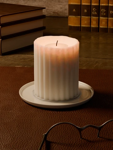 A fluted candle burning in a library